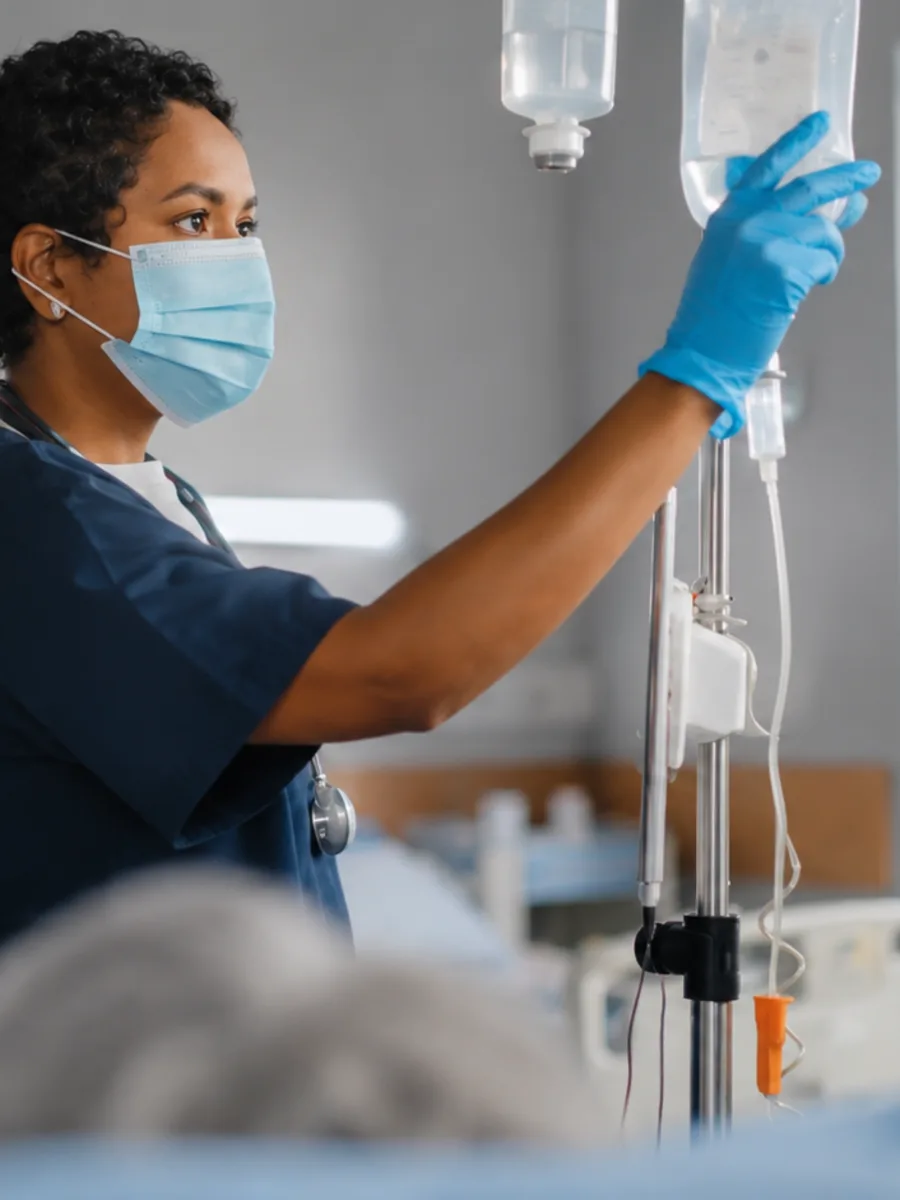 Enfermeira ajustando o soro de um paciente em um hospital americano: o destino da última milha