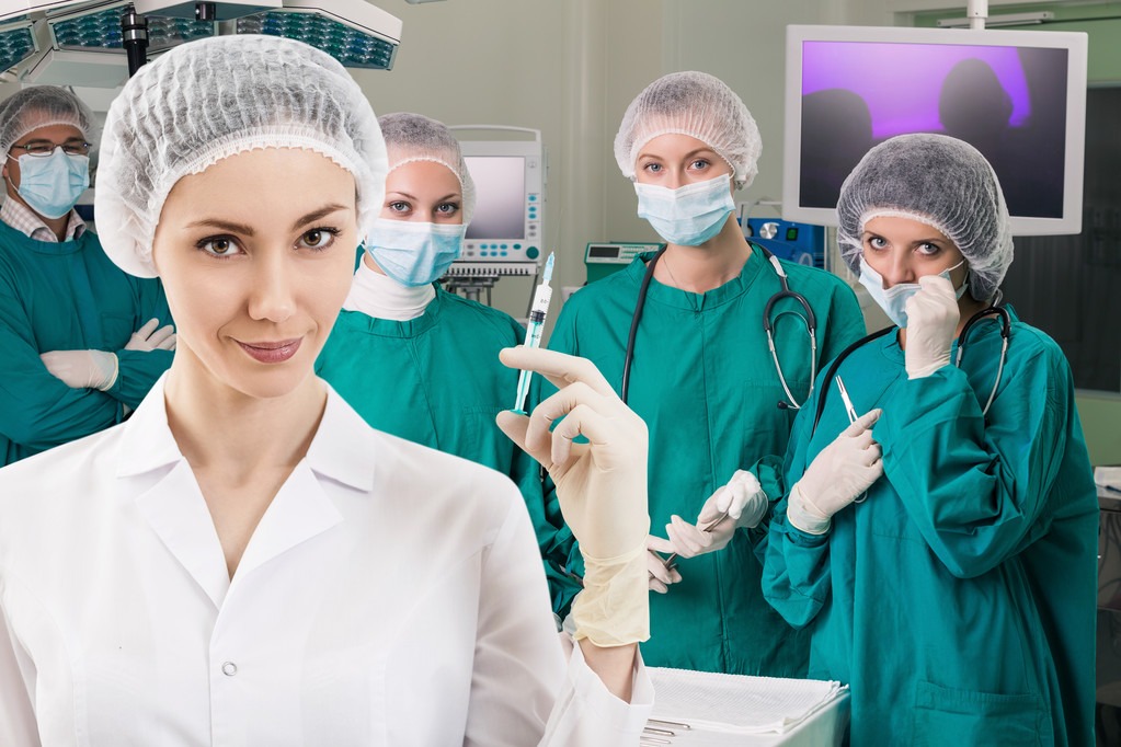 Young female anesthetist with syringe on the surgery teem background
